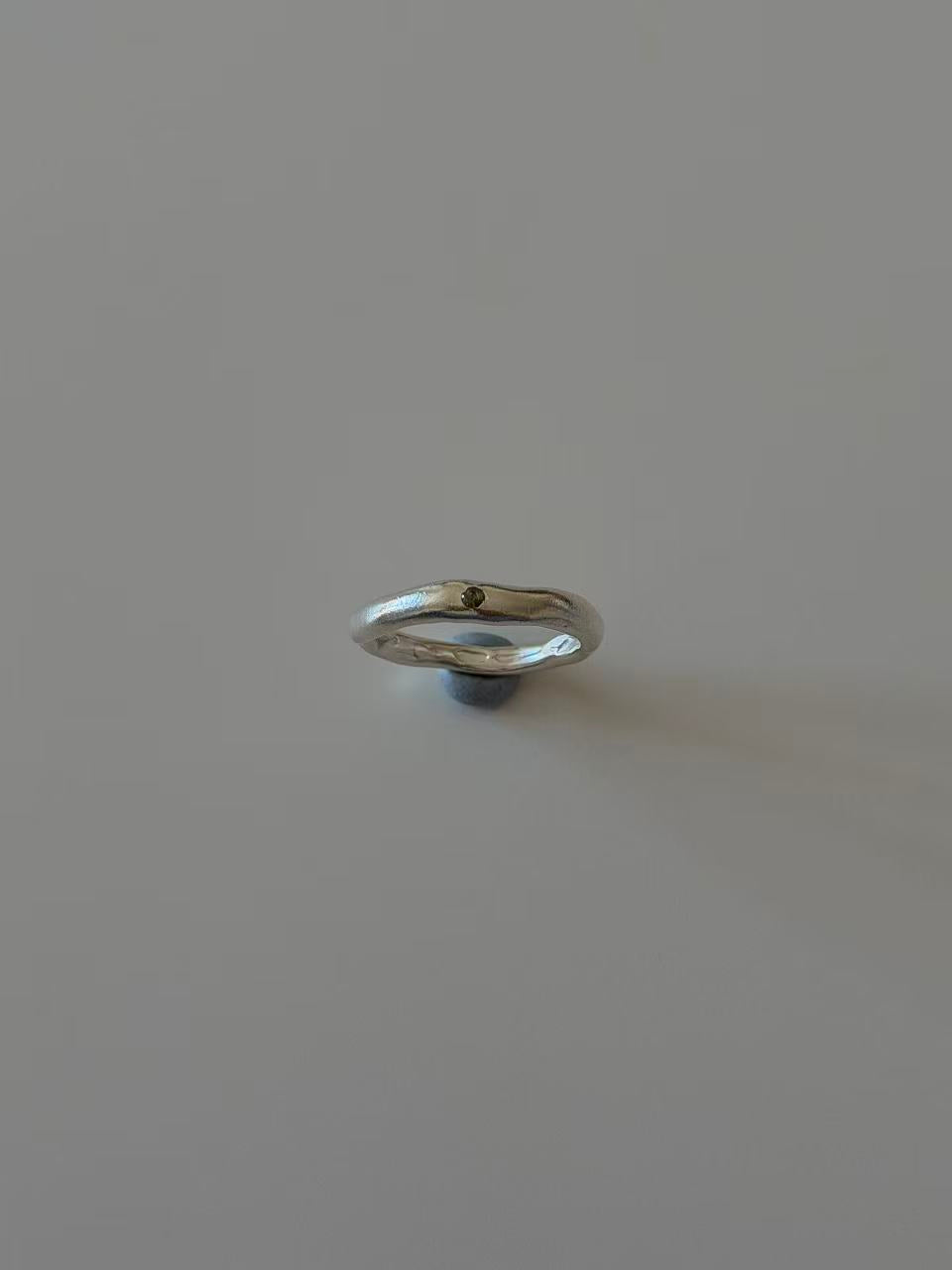 Detail of the olive-green stone in the handmade silver ring